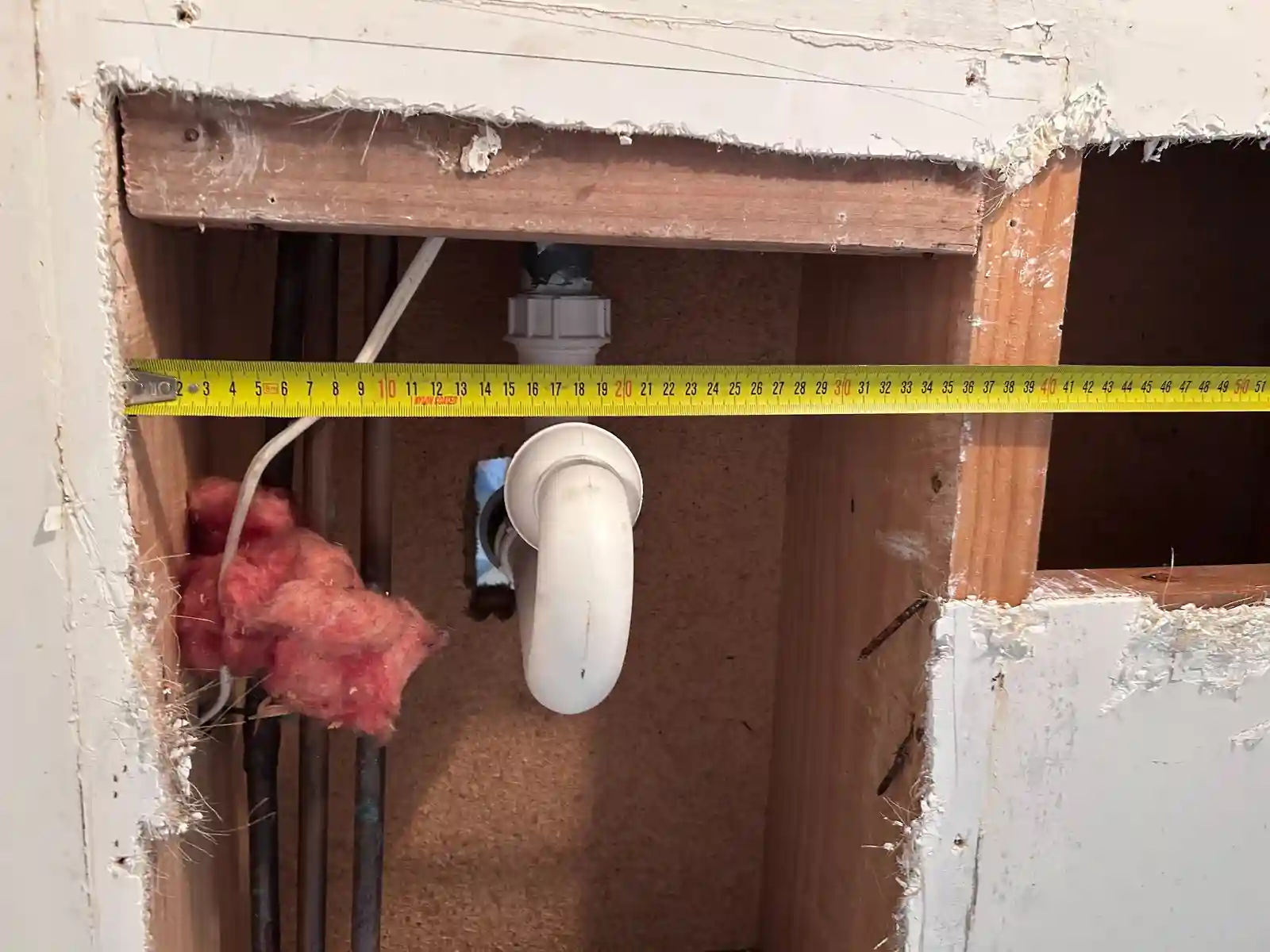 Site verification photo showing measuring tape used to confirm framing and spacing